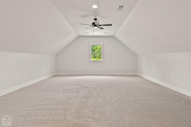 bonus room with ceiling fan, lofted ceiling, baseboards, and a textured ceiling