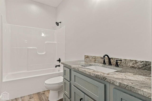 full bathroom featuring toilet, wood finished floors, vanity, and shower / washtub combination