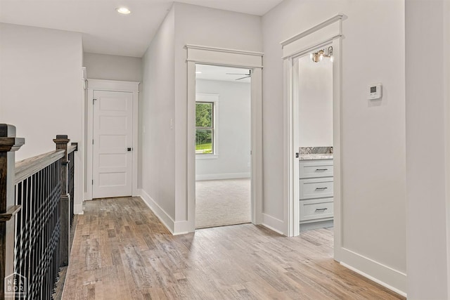 hall with light wood-style flooring, recessed lighting, and baseboards