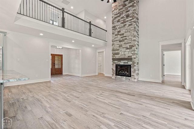 unfurnished living room featuring visible vents, baseboards, a fireplace, light wood finished floors, and recessed lighting