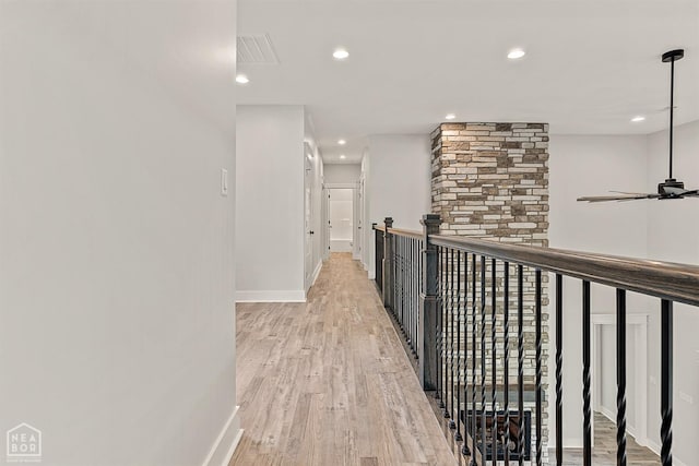 corridor featuring wood finished floors, baseboards, visible vents, and recessed lighting