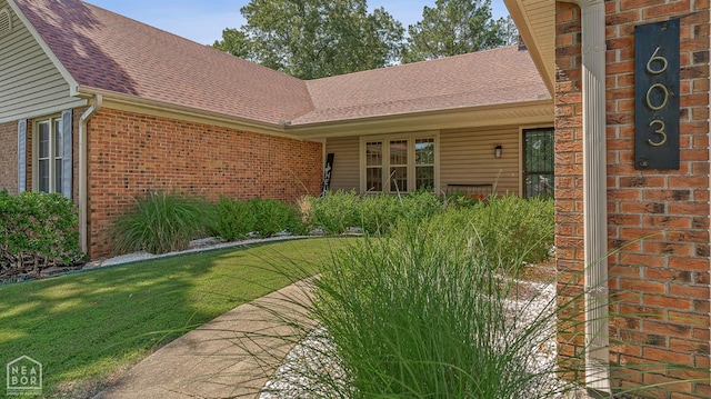 603 Arrowhead Dr, Jonesboro, AR 72401 - doorway to property featuring brick siding, a yard, and a shingled roof