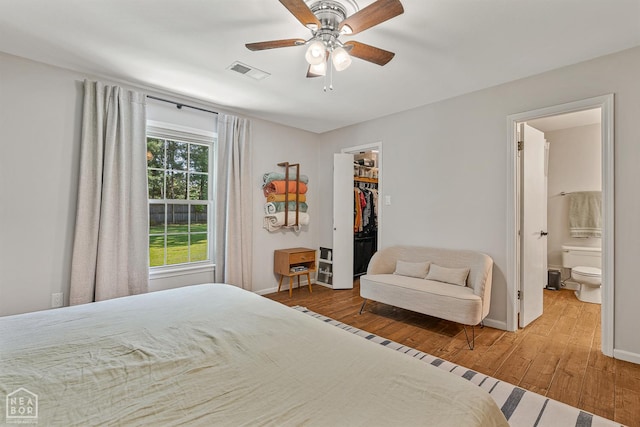 603 Arrowhead Dr, Jonesboro, AR 72401 - bedroom featuring hardwood / wood-style floors, baseboards, a walk in closet, ensuite bath, and a ceiling fan