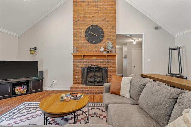 603 Arrowhead Dr, Jonesboro, AR 72401 - living area with vaulted ceiling, light wood-type flooring, ornamental molding, a brick fireplace, and baseboards