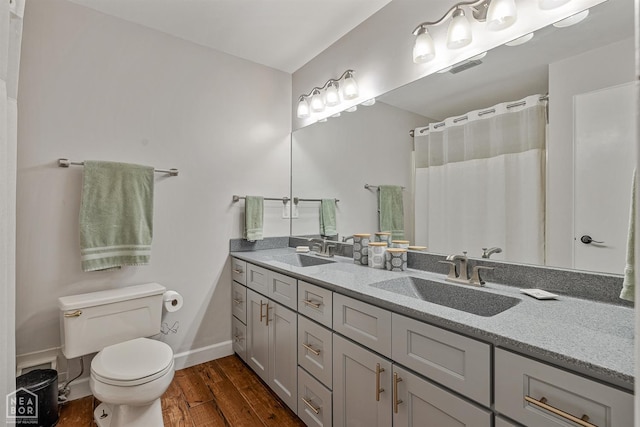 603 Arrowhead Dr, Jonesboro, AR 72401 - full bath with wood finished floors, double vanity, toilet, baseboards, and curtained shower
