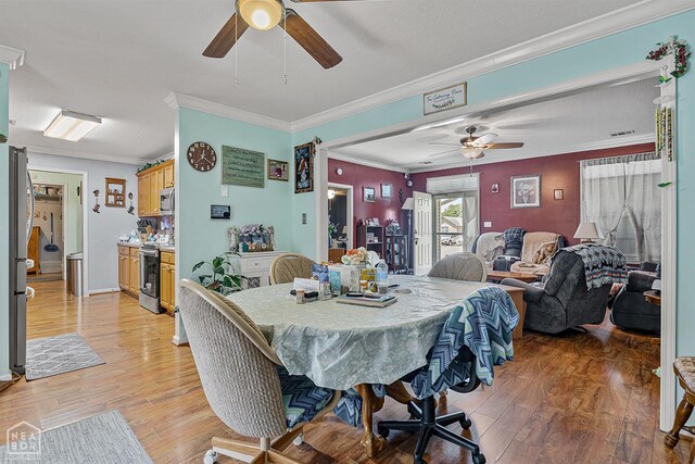 dining room with crown molding, ceiling fan, and light wood finished floors