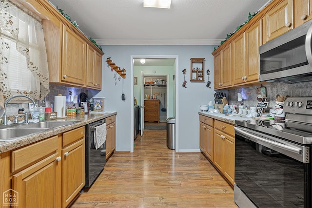 kitchen with light wood-style floors, decorative backsplash, a sink, and stainless steel appliances