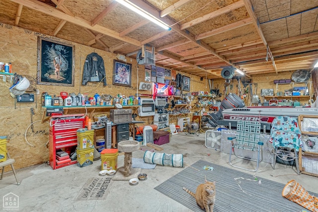 misc room with unfinished concrete flooring and a workshop area