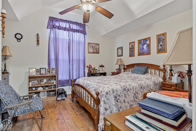 bedroom with a ceiling fan, vaulted ceiling, and wood finished floors