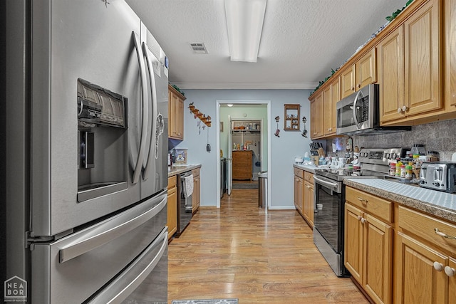 kitchen with visible vents, light countertops, light wood-type flooring, crown molding, and stainless steel appliances