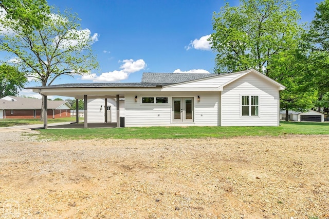 back of property with french doors, a lawn, and roof with shingles