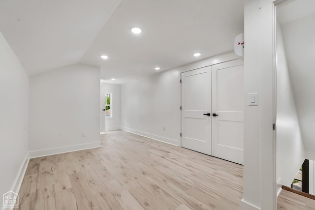additional living space with recessed lighting, baseboards, and light wood-type flooring