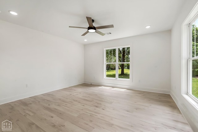 spare room featuring visible vents, a ceiling fan, light wood-style flooring, and a healthy amount of sunlight