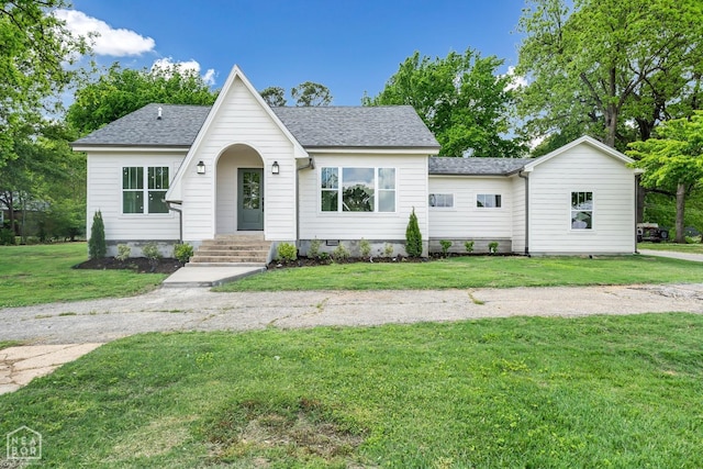 view of front of property with a shingled roof and a front lawn