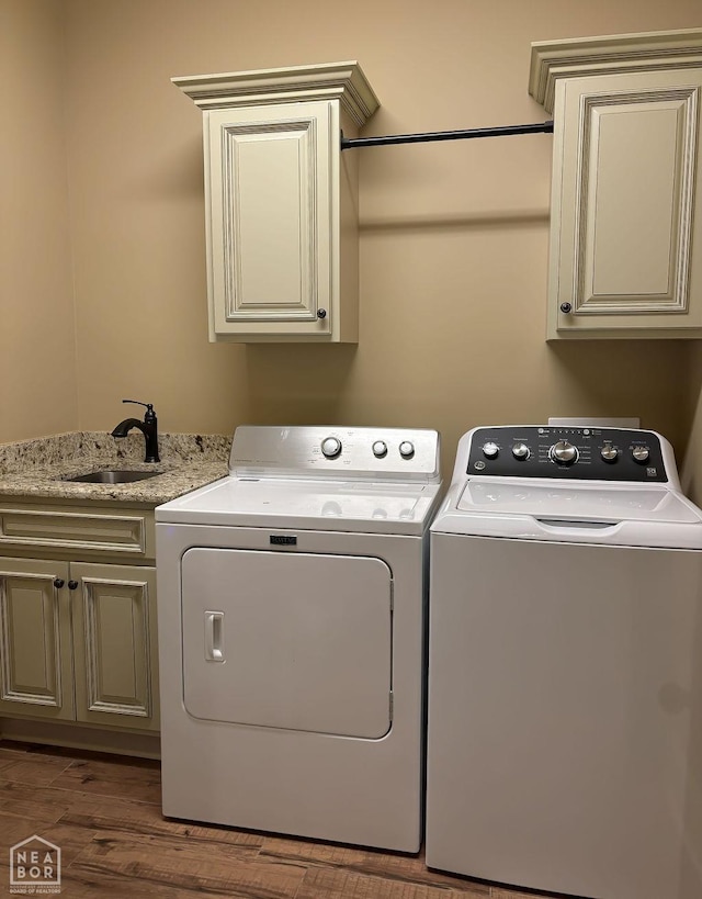 4228 Villa Cv, Jonesboro, AR 72405 - washroom featuring separate washer and dryer, cabinet space, and wood finished floors