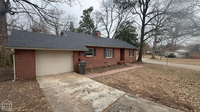 621 W Thomas Ave, Jonesboro, AR 72401 - view of front of property featuring a chimney, driveway, an attached garage, brick siding, and a shingled roof