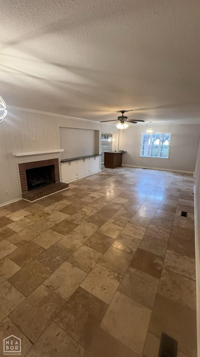 621 W Thomas Ave, Jonesboro, AR 72401 - unfurnished living room featuring a brick fireplace, a textured ceiling, baseboards, and ceiling fan