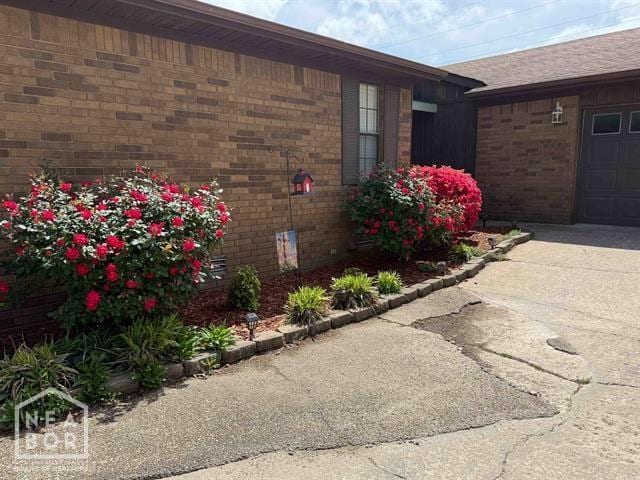view of side of property with brick siding and concrete driveway