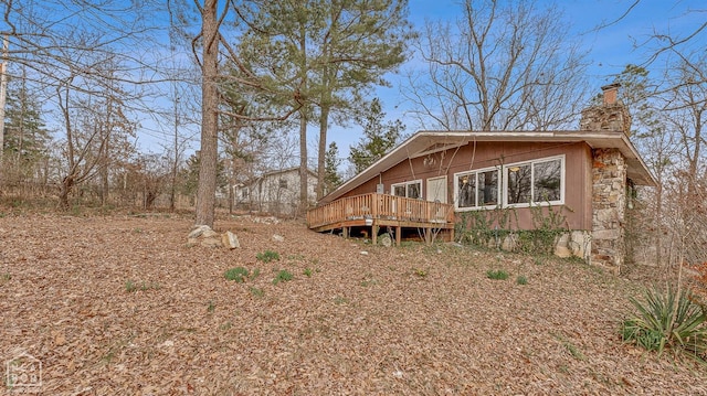 back of house featuring a chimney and a deck