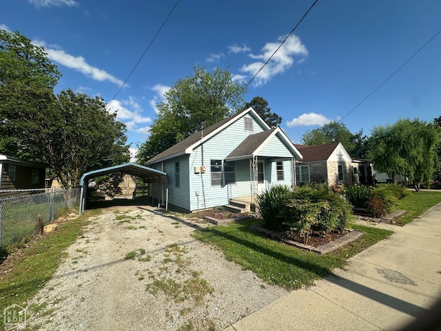 bungalow-style house with fence, a porch, a carport, and driveway