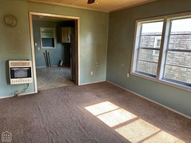 carpeted empty room featuring crown molding and heating unit