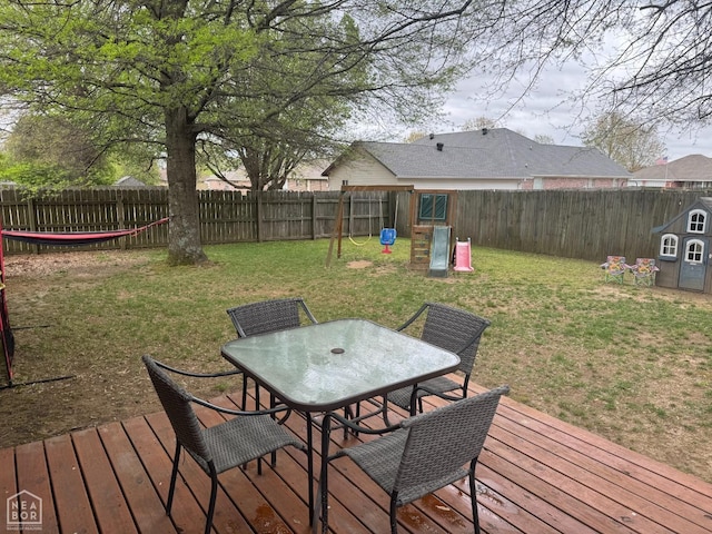 deck with a yard, a fenced backyard, a playground, and outdoor dining area