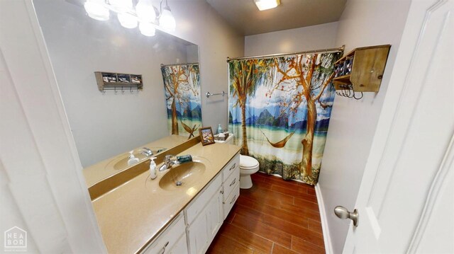 bathroom featuring toilet, curtained shower, vanity, and wood finish floors
