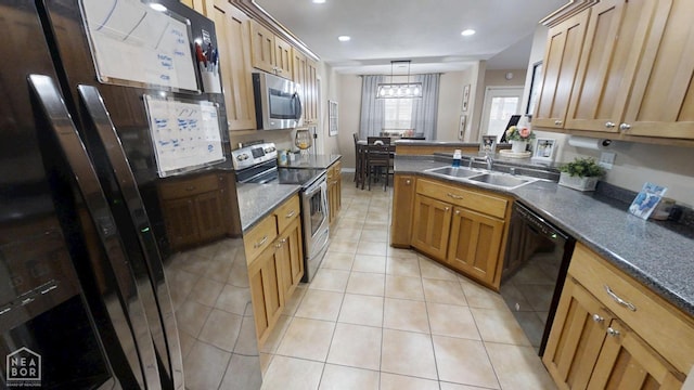 kitchen with dark countertops, light tile patterned floors, a sink, and appliances with stainless steel finishes