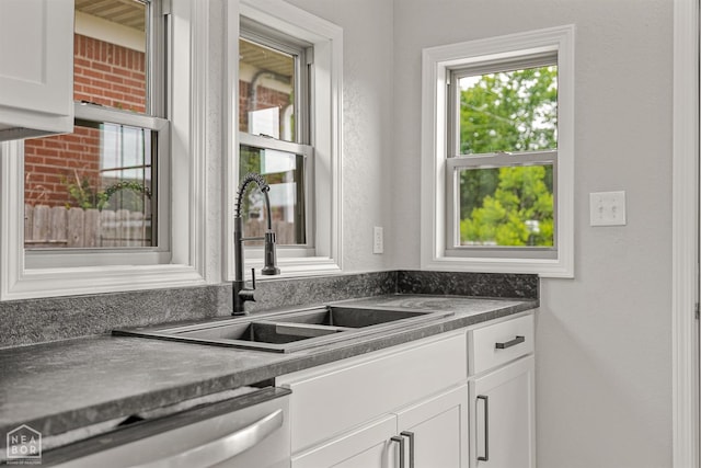 617 S 7th St, Paragould, AR 72450 - kitchen featuring a sink, dishwasher, white cabinetry, and dark countertops