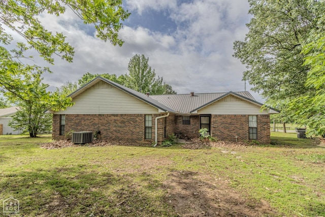 rear view of property with a lawn, central AC, and brick siding