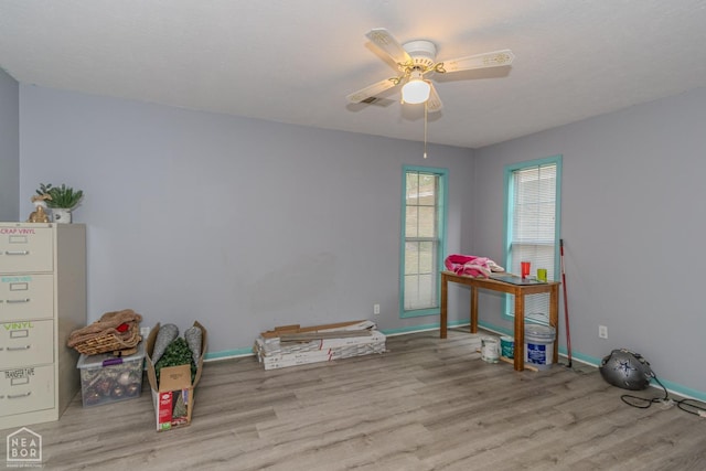 playroom with baseboards, ceiling fan, and wood finished floors