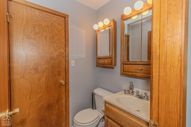 half bathroom with vanity and toilet