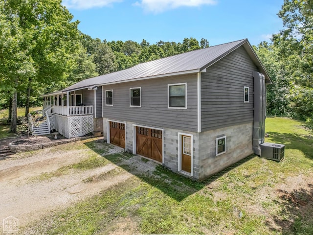 200 Law 296 Rd, Black Rock, AR 72415 - back of property featuring driveway, a metal roof, stairway, a yard, and a garage