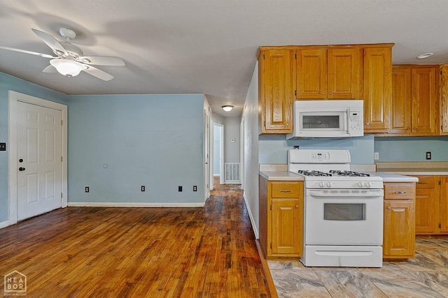 kitchen with white appliances, light countertops, brown cabinetry, and ceiling fan