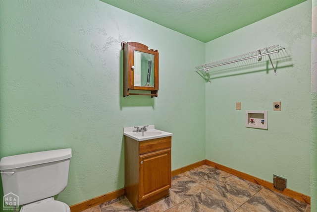 laundry area featuring electric dryer hookup, a sink, hookup for a washing machine, and baseboards