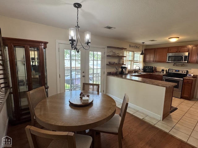900 Sycamore Cv, Jonesboro, AR 72404 - dining room with french doors, a chandelier, and light wood-style floors