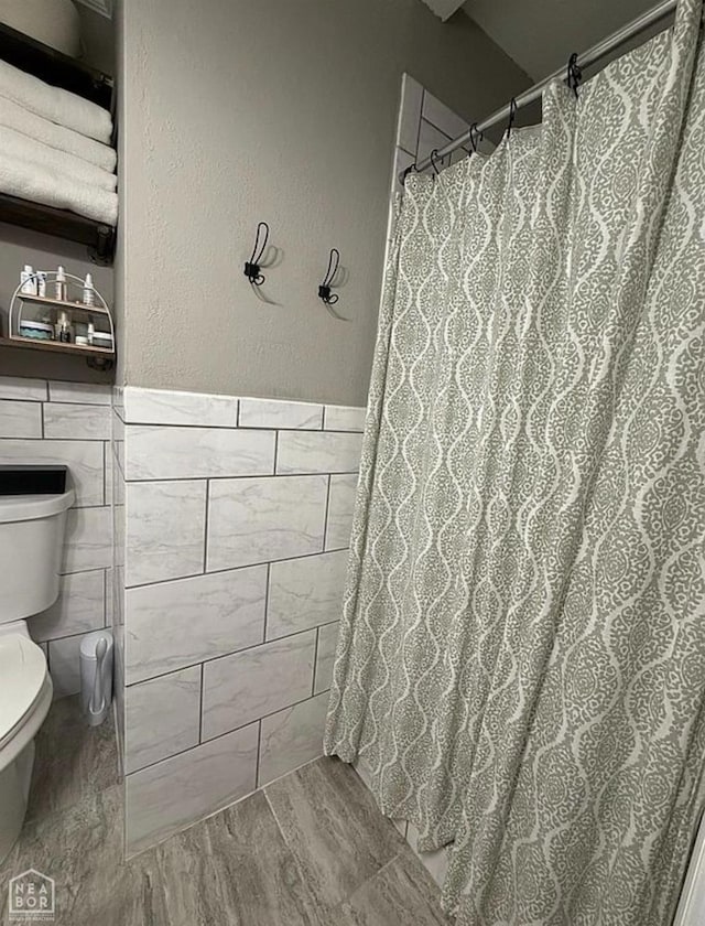 900 Sycamore Cv, Jonesboro, AR 72404 - bathroom with toilet, tile walls, and a shower with curtain