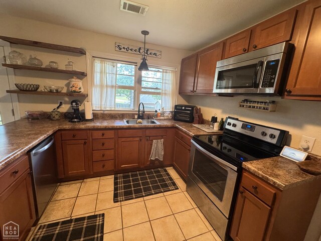 900 Sycamore Cv, Jonesboro, AR 72404 - kitchen featuring stainless steel appliances, a sink, dark countertops, and light tile patterned floors
