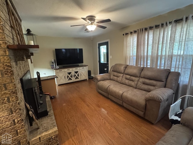 900 Sycamore Cv, Jonesboro, AR 72404 - living room with dark wood finished floors, ceiling fan, and a brick fireplace