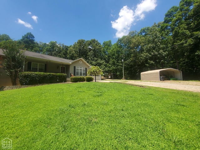 2590 W N St, Piggott, AR 72454 - view of front facade featuring a front lawn, dirt driveway, and a carport