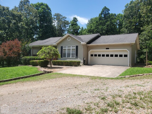 2590 W N St, Piggott, AR 72454 - ranch-style house with concrete driveway, an attached garage, and a front yard
