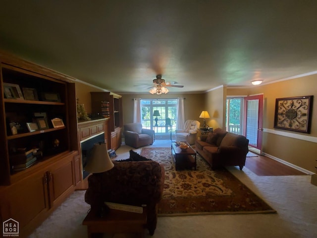 2590 W N St, Piggott, AR 72454 - carpeted living area with a fireplace, ornamental molding, and a ceiling fan