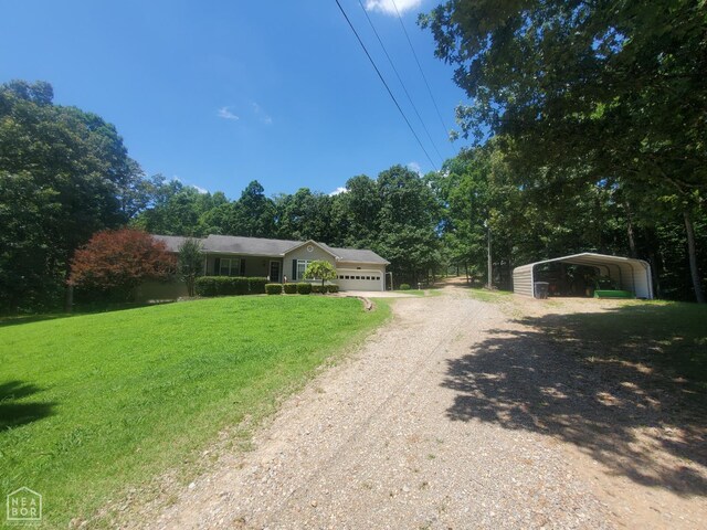2590 W N St, Piggott, AR 72454 - ranch-style house featuring dirt driveway, a front lawn, an attached garage, and a carport