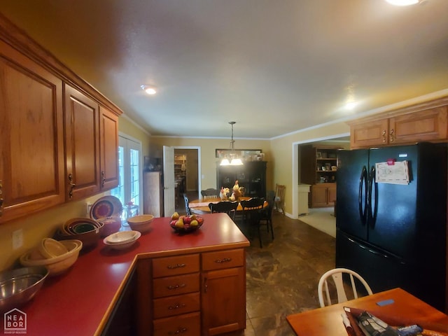 2590 W N St, Piggott, AR 72454 - kitchen featuring freestanding refrigerator, a peninsula, ornamental molding, hanging light fixtures, and brown cabinets