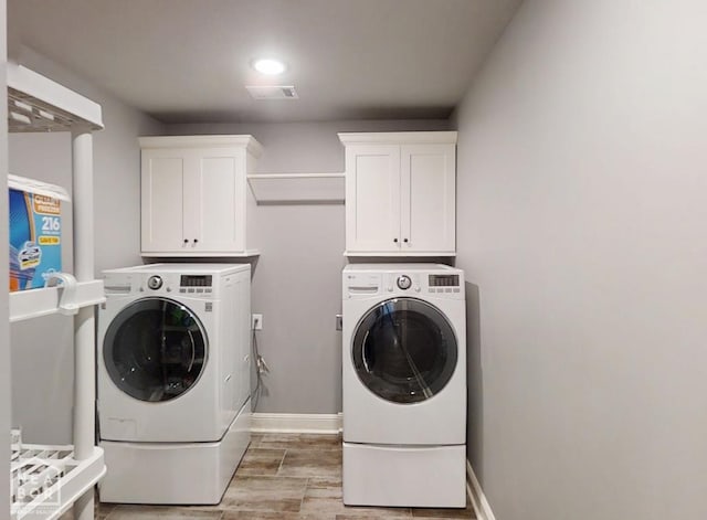 6509 Merrell Dr, Jonesboro, AR 72404 - washroom featuring separate washer and dryer, light wood-style floors, and cabinet space
