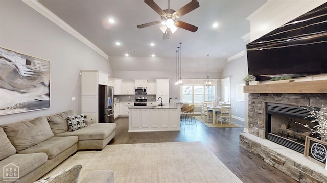 6509 Merrell Dr, Jonesboro, AR 72404 - living area featuring lofted ceiling, crown molding, a ceiling fan, dark wood finished floors, and a fireplace