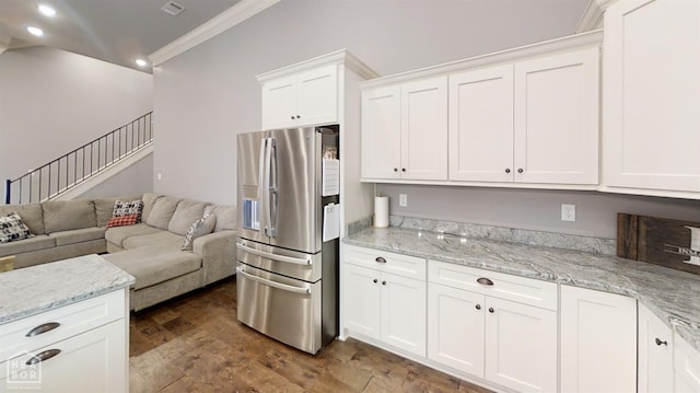 6509 Merrell Dr, Jonesboro, AR 72404 - kitchen with stainless steel fridge with ice dispenser, ornamental molding, open floor plan, white cabinetry, and light stone countertops