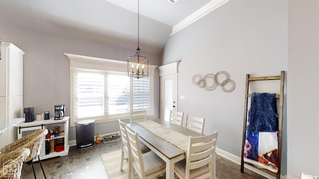 6509 Merrell Dr, Jonesboro, AR 72404 - dining area with lofted ceiling, dark wood-type flooring, a chandelier, and baseboards