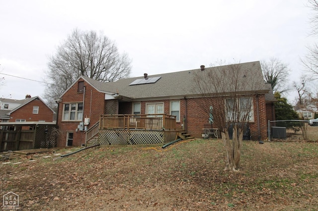back of property featuring a wooden deck, fence, and brick siding