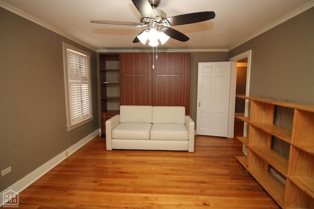 living area with crown molding, a ceiling fan, and light wood-style floors